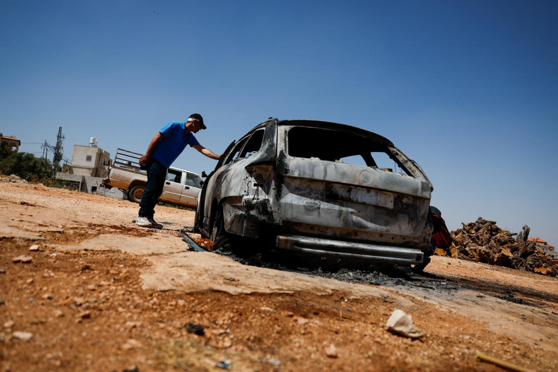 A Palestinian man inspects a burnt car after an attack by Israeli settlers in Kafr Malik, in the Israeli-occupied West Bank. The territory is on a World Bank list of economies facing conflict or instability. (Reuters)