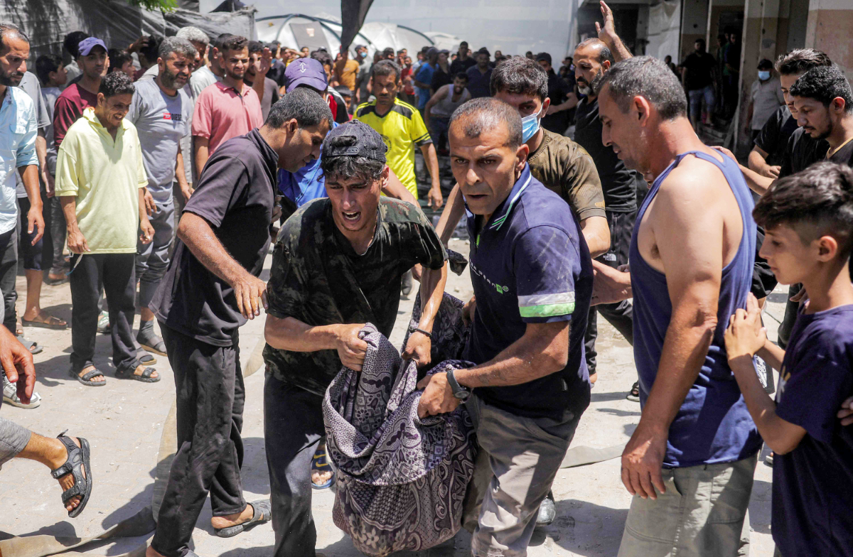 Men carry away the body of a victim who was killed in a blaze following an Israeli strike at the UNRWA’s Osama bin Zaid school in western Jabalia in the northern Gaza Strip. (AFP)
