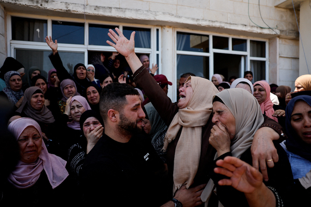 Mourners react during the funeral of Palestinian youths who were killed during an attack by Israeli settlers in Kafr Malik, in the Israeli-occupied West Bank, June 26, 2025. (Reuters)