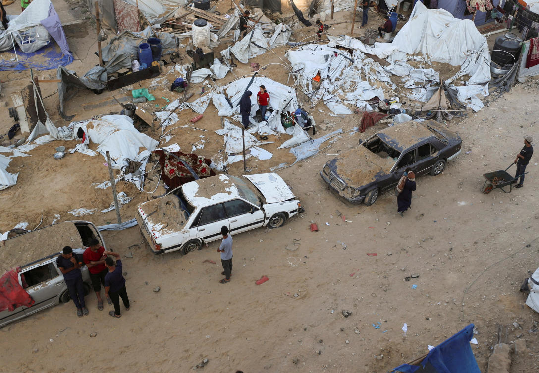 Palestinians gather at the site of a tent camp that was struck by an Israeli airstrike on Friday in Gaza City, on June 28, 2025. (Reuters)