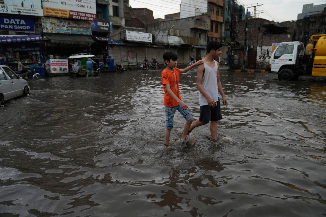 Youth wade through a flooded road caused by heavy monsoon rains, in Lahore, Pakistan, Sunday, June 29, 2025. (AP)