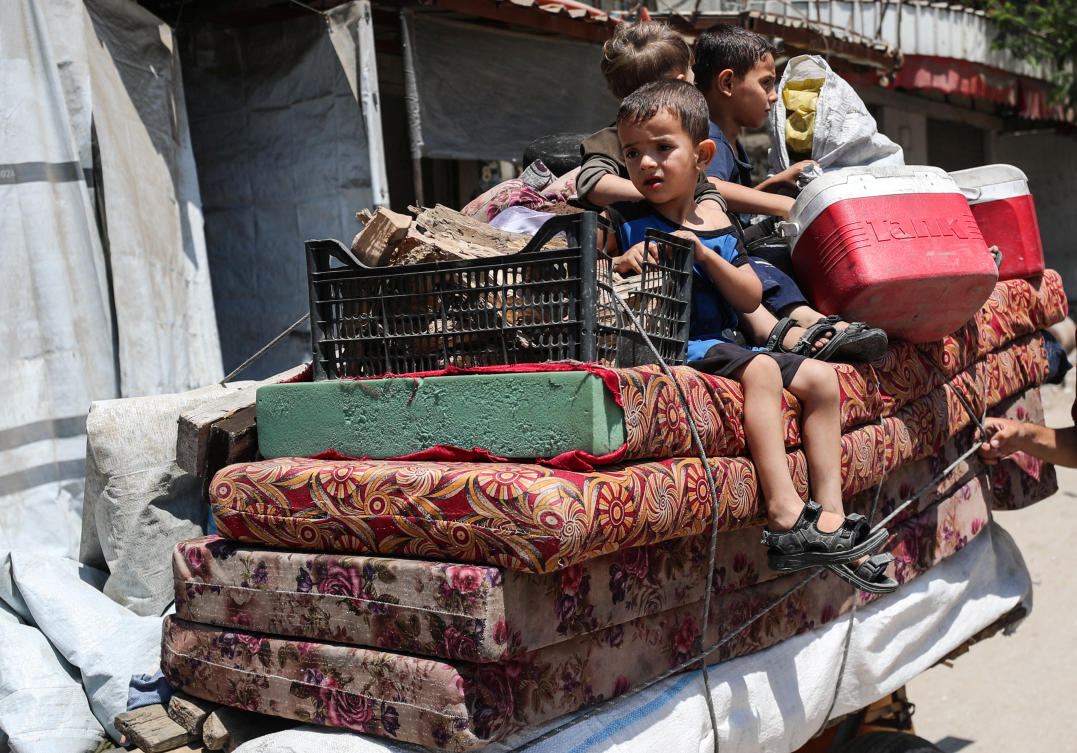 A child looks on as Palestinians flee their homes with their belongings after the Israeli army issued evacuation orders, in Gaza City, June 29, 2025. (Reuters)