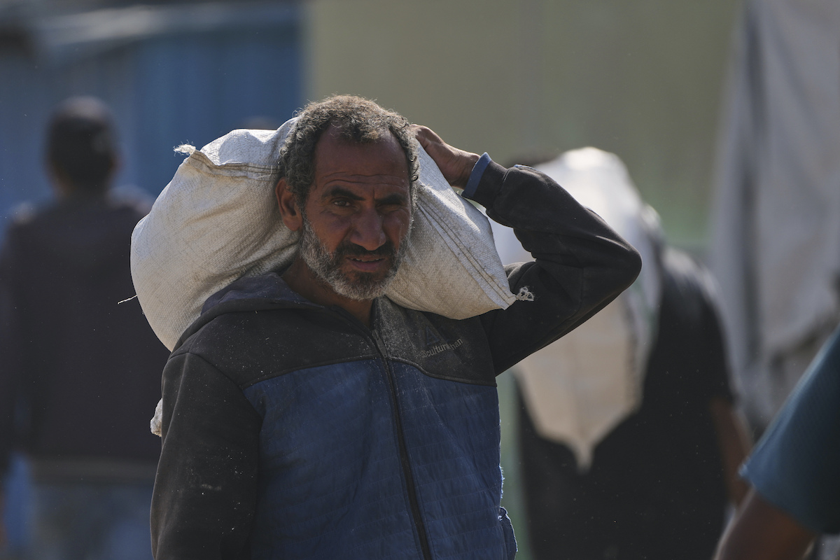 A Palestinian man carries a bag of food after receiving aid from the Gaza Humanitarian Foundation. (AP)