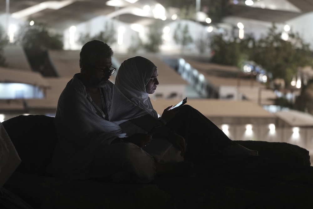 Muslim pilgrims use their mobile phones to read chapters from the Holy Qur’an atop Mount Arafat on June 5, 2025. (AP)
