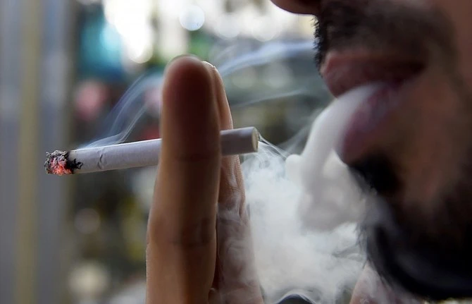 A man smokes outside a tobacco shop in the Saudi capital Riyadh late on June 11, 2017. (AFP/File)