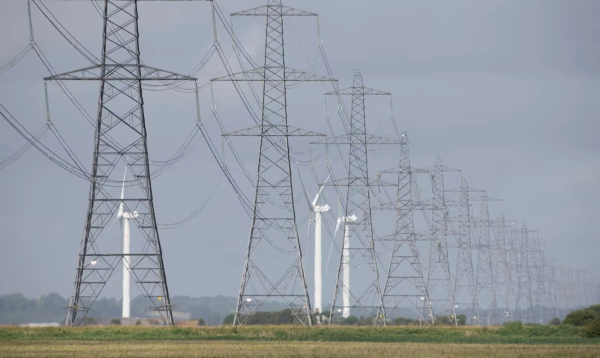 Onshore wind turbines at Little Cheyne Court Wind Farm operate beside electricity pylons in Dungeness, Britain. (Reuters/File)