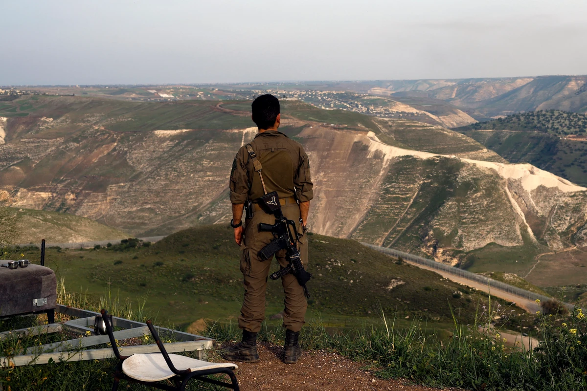 An Israeli soldier stands at a lookout point in the Israel-occupied and annexed Golan Heights overlooking southern Syria, March 25, 2025. (AFP)