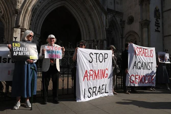 Pro-Palestinian activists and supporters hold placards outside the Royal Courts of Justice in central London on May 13, 2025. (AFP/File Photo)