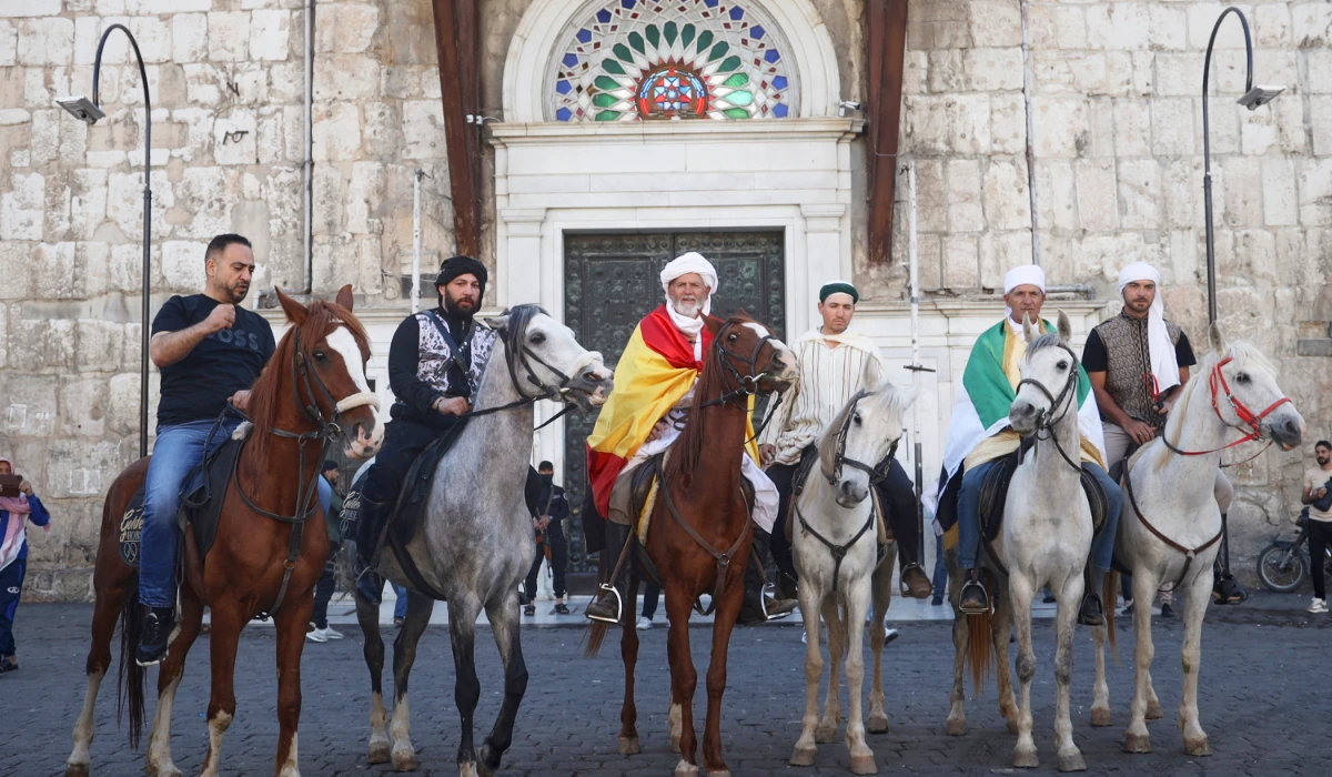Pilgrims, including three from Spain, pose with their horses outside the Souq al-Hamidiyah market during their months-long horseback journey from Spain to Saudi Arabia to perform the Hajj, in Damascus, Syria, April 21, 2025. (AP)