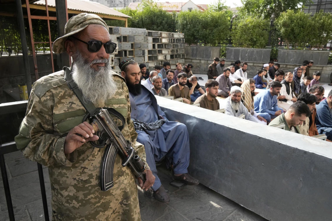 Afghan Muslims perform Eid Al-Adha prayer while a Taliban fighter stands guard in the Shah-Do Shamshira Mosque in Kabul, Afghanistan, June 7, 2025. (AP)