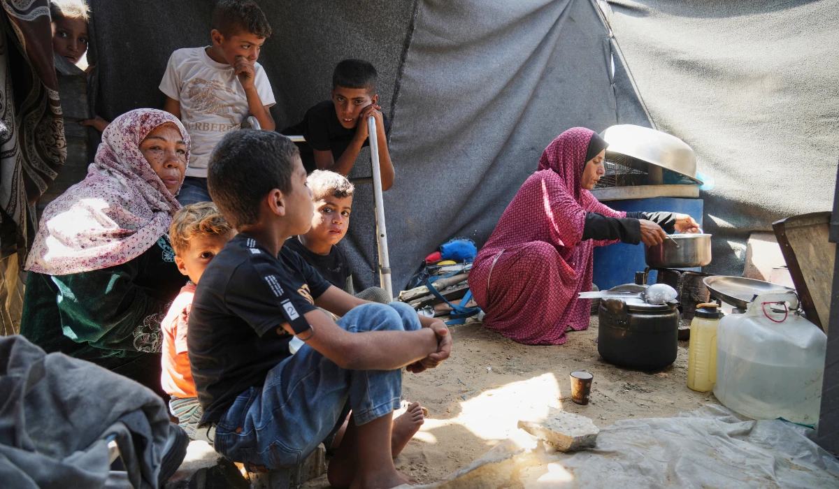 Tahreer Abu Jazar, 36, right, prepares an Eid al-Adha meal for her family inside their tent at a camp for displaced Palestinians in Mawasi Khan Younis, Gaza Strip, on Friday, June 6, 2025. (AP)