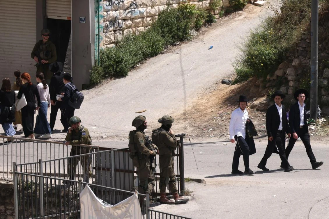 Israeli army soldiers stand guard as Ultra-Orthodox Jews visit the shrine of Atnaeil Ben Kinaz in the city of Hebron in the Israeli-occupied West Bank on April 16, 2025. (AFP)