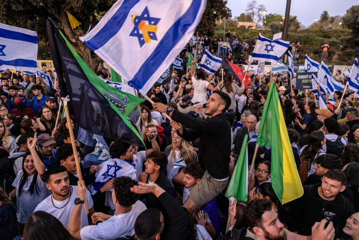 Demonstrators hold military and Israeli flags during a protest in front of the Knesset (Israeli parliament) in Jerusalem on April 2, 2025, calling for the goverment to enforce the mandatory military service to all people, including ultra-Orthodox Jewish men. (AFP)