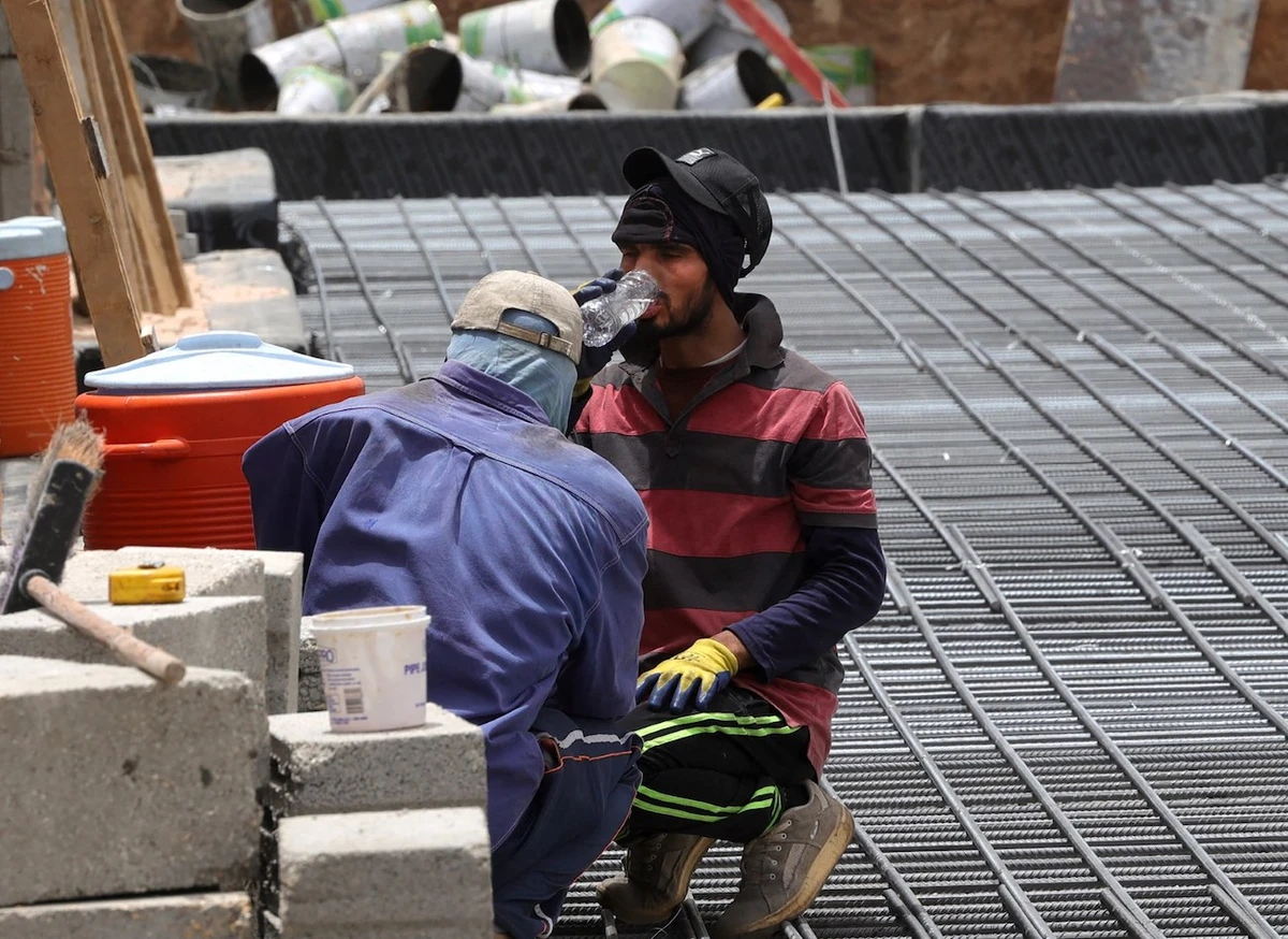 A labourer has a drink of water from a plastic bottle at a construction site in Riyadh. (File/AFP)
