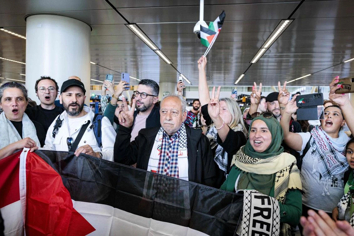 Participants in the March to Gaza flash the victory sign as they depart from Schiphol Airport for Egypt, on Wednesday. (AFP)