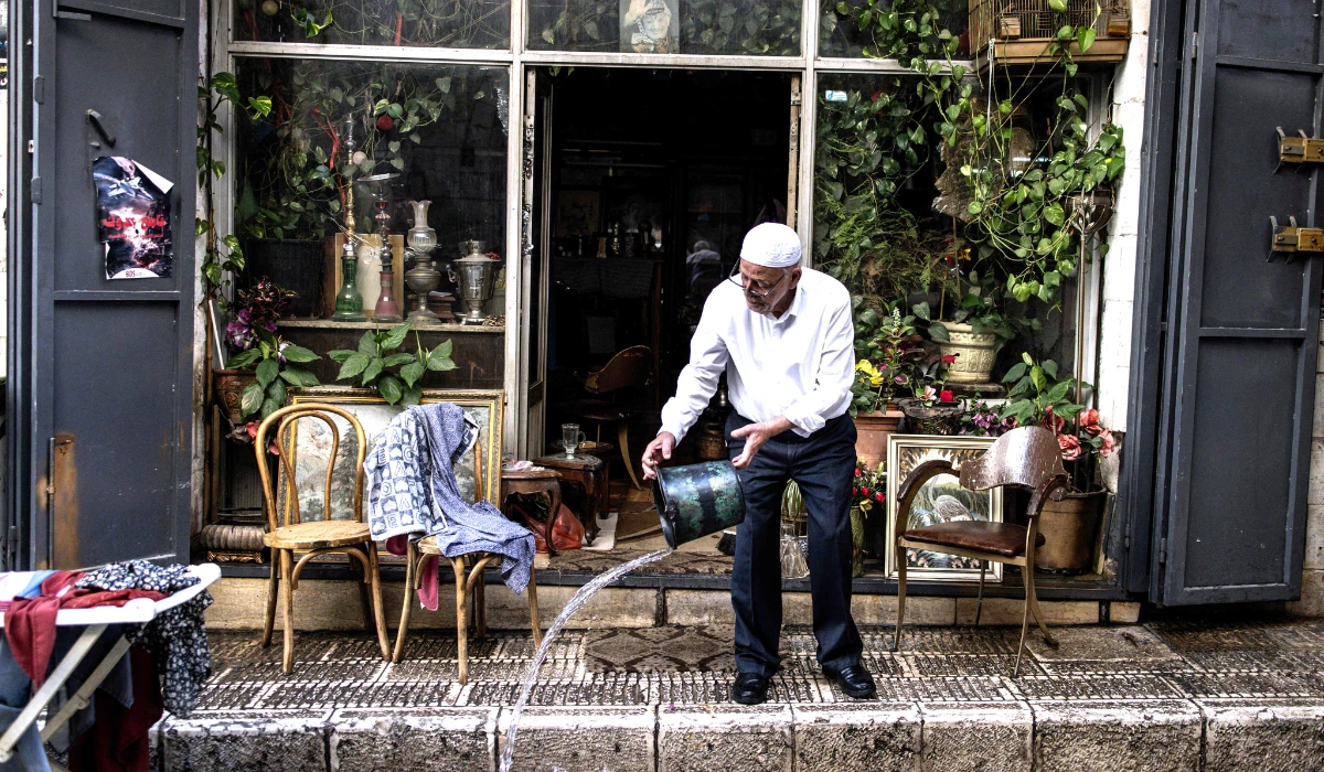 A Palestinian man cleans his shop a day after a large-scale Israeli military raid in the old town of Nablus city in the occupied West Bank on June 11, 2025. (AFP)