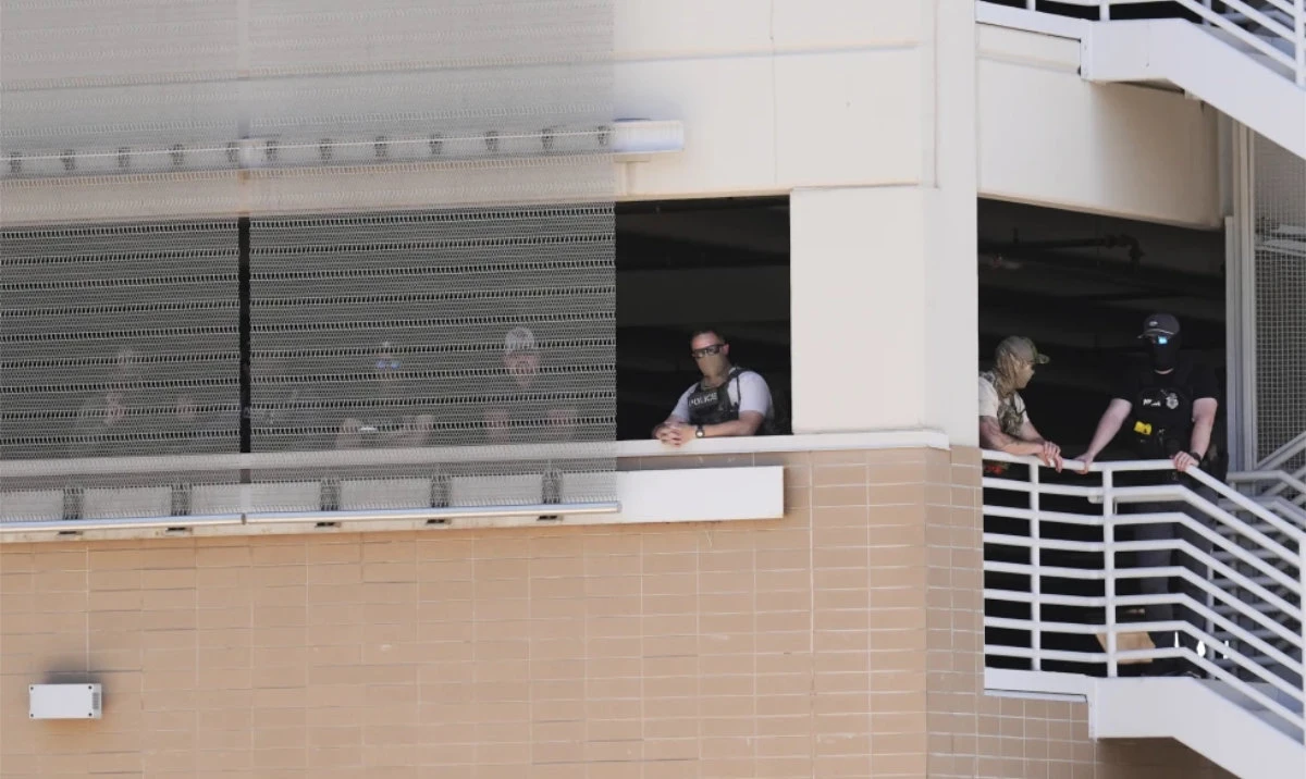 Federal law enforcement wait in a parking garage to take people into custody outside immigration court, in Phoenix. (AP/File)