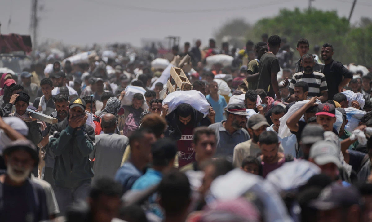 Palestinians carry bags containing food and humanitarian aid packages delivered by the Gaza Humanitarian Foundation, a US-backed organization, in Rafah, southern Gaza Strip, June 9, 2025. (AP)