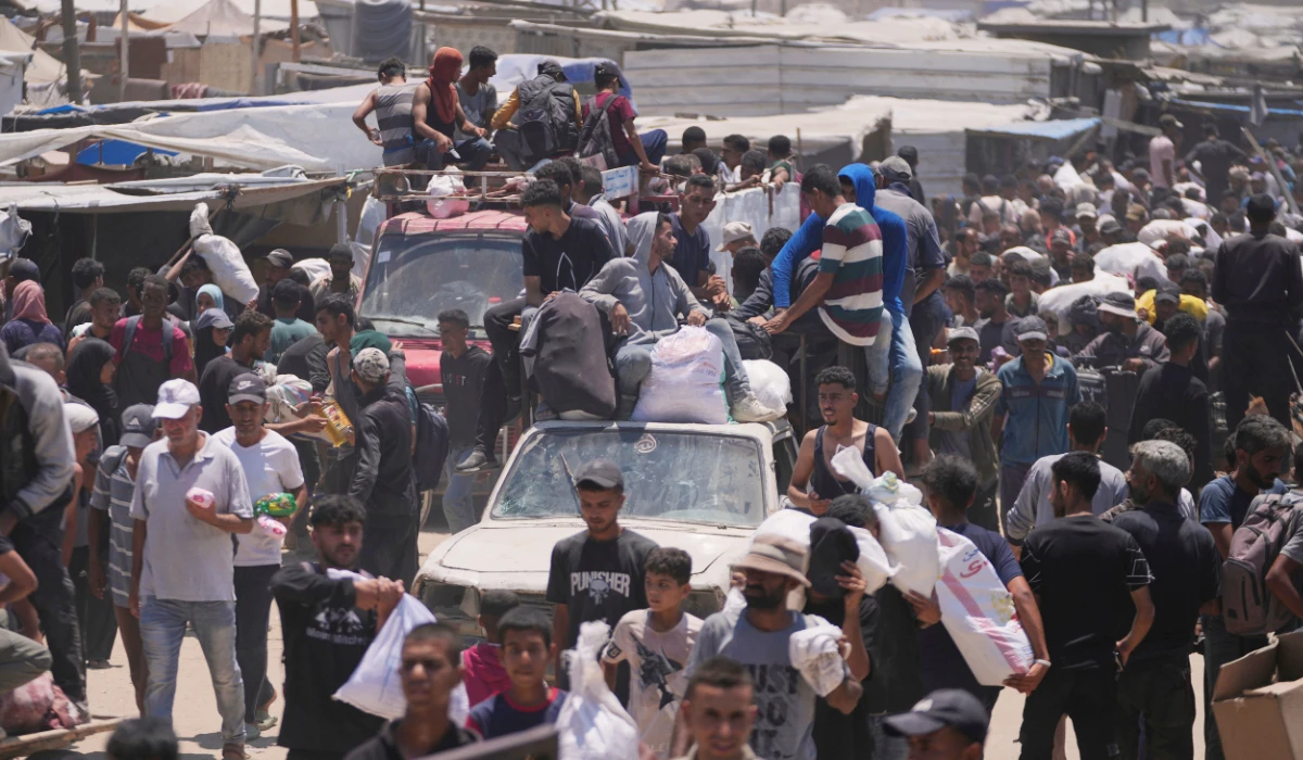 Palestinians carry bags containing food and humanitarian aid packages delivered by the Gaza Humanitarian Foundation, a U.S.-backed organization, in Rafah, southern Gaza Strip, Wednesday, June 11, 2025. (AP)