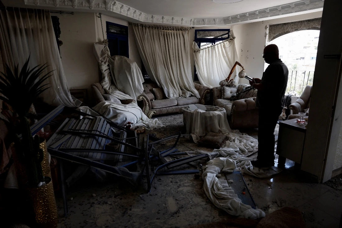 A man stands inside a damaged room after missiles fired from Iran hit a residential building in Tamra, Israel. (Reuters)