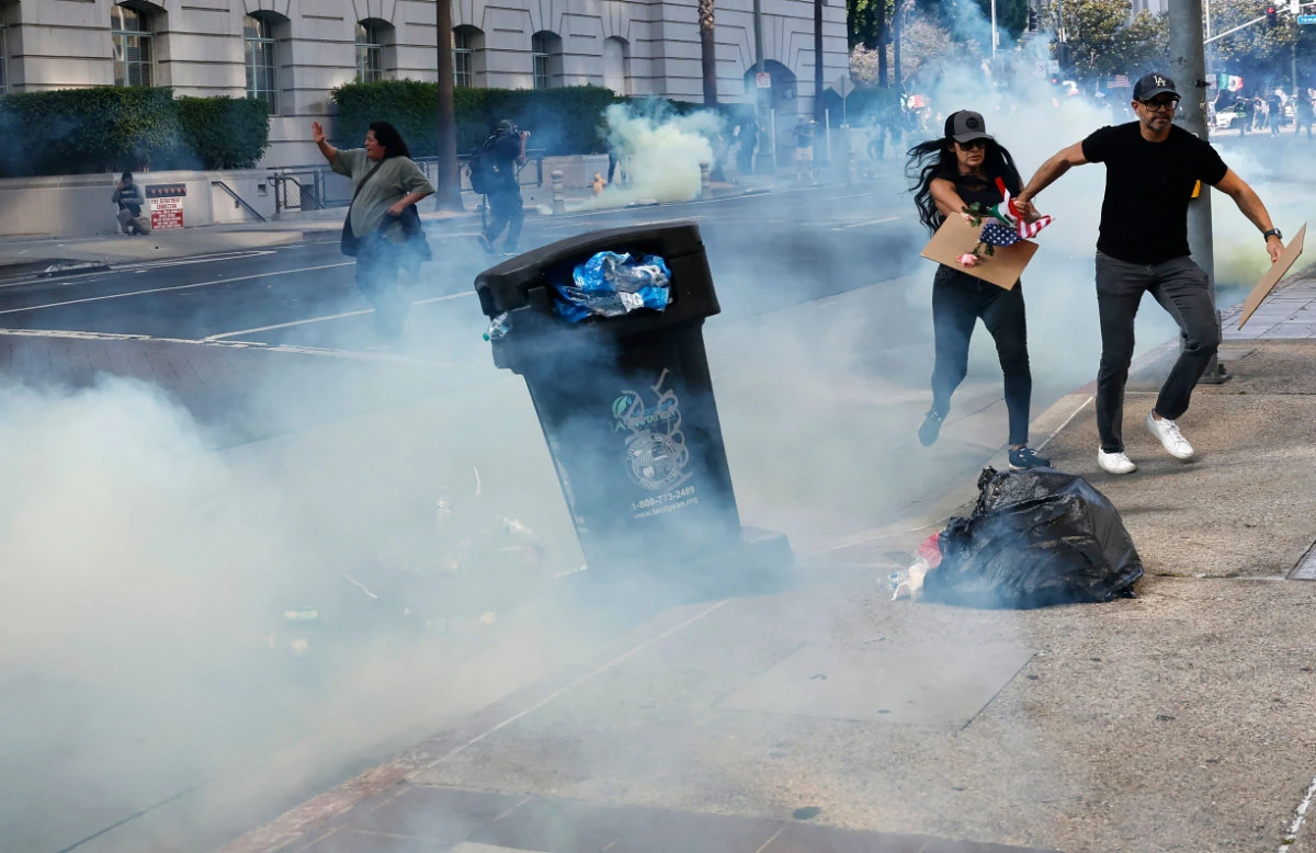 Protesters run from tear gas as police clear a street of demonstrators in front of City Hall after an "unlawful assembly" was declared on June 14, 2025 in Los Angeles, California. (Getty Images via AFP)