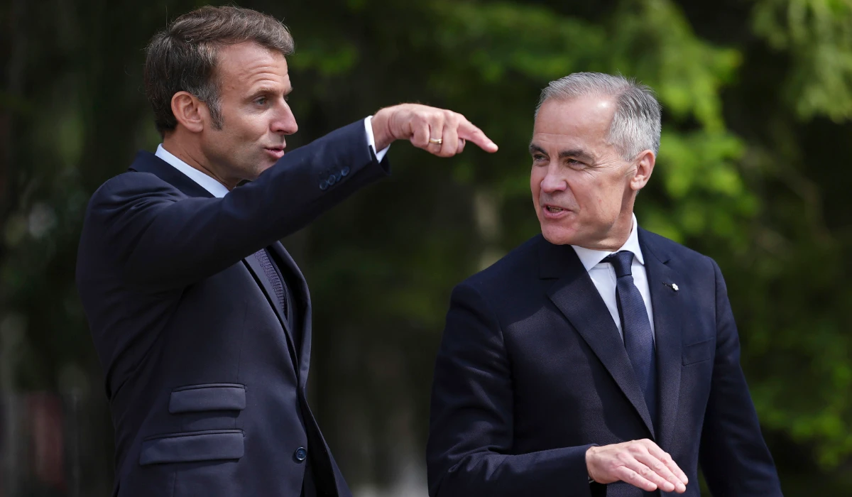 French President Emmanuel Macron, left, and Canadian Prime Minister Mark Carney walk to a meeting after officially welcoming Macron to the G7 Summit in Kananaskis, Alberta, Canada, Monday, June 16, 2025. (AP)