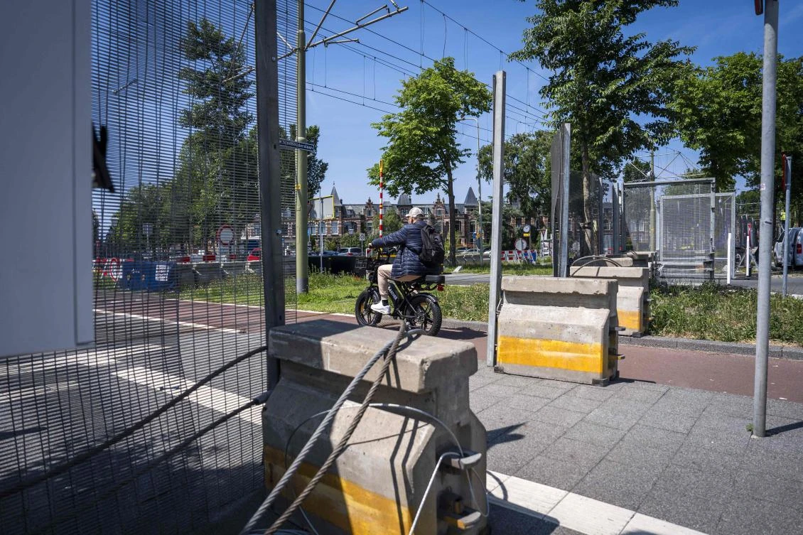 A cyclist rides past fences and barriers erected in The Hague on June 18, 2025, ahead of the NATO summit. (ANP/AFP)