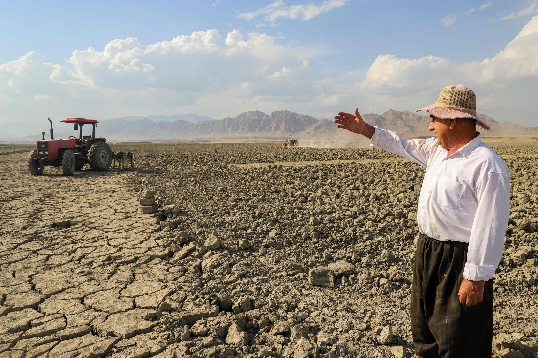 Hussein Khedr Shekha, a farmer, gestures as he speaks by a field near the village of Sarsian, at the edge of the Dukan dam reservoir in the KRG. (AFP)