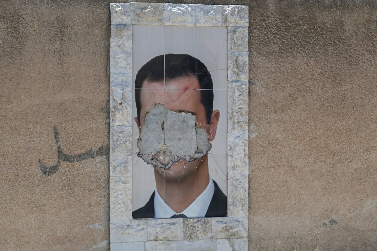 A defaced portrait of Syria's ousted president Bashar al-Assad hangs on a wall in the capital Damascus, June 2, 2025. (AFP)