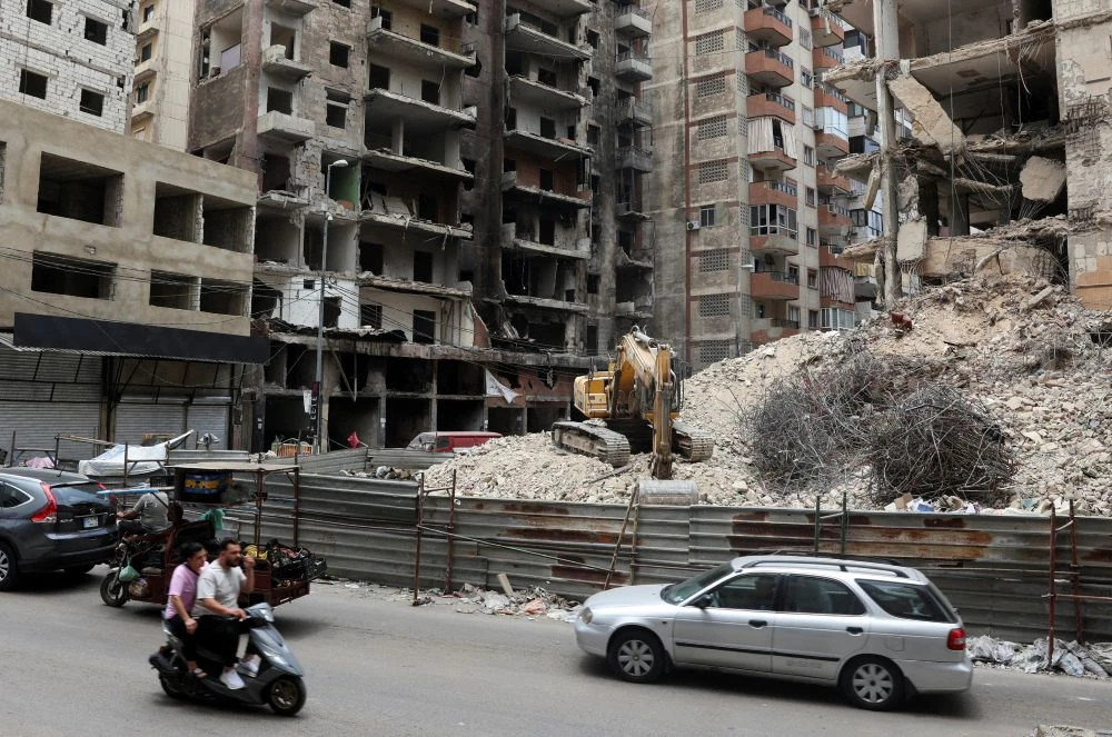 Cars and motorbikes drive near damaged buildings in Beirut’s southern suburbs, Lebanon, June 23, 2025. (Reuters)