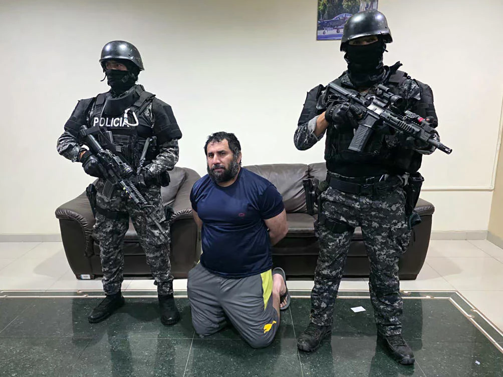 Adolfo Macias, alias Fito, being guarded after his recapture in Manta, Manabi Province, Ecuador, on June 25, 2025. (Ecuadorean Army/AFP)