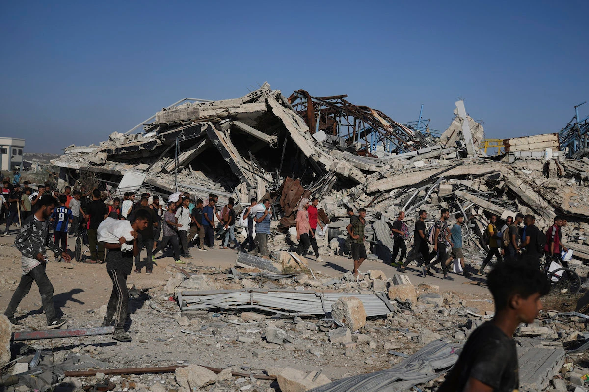 Palestinians carry aid packages from a distribution center in Gaza Thursday. Members of the largest representative body for Jews in the UK have been disciplined for criticizing Israel's conduct of the conflict. (AP)