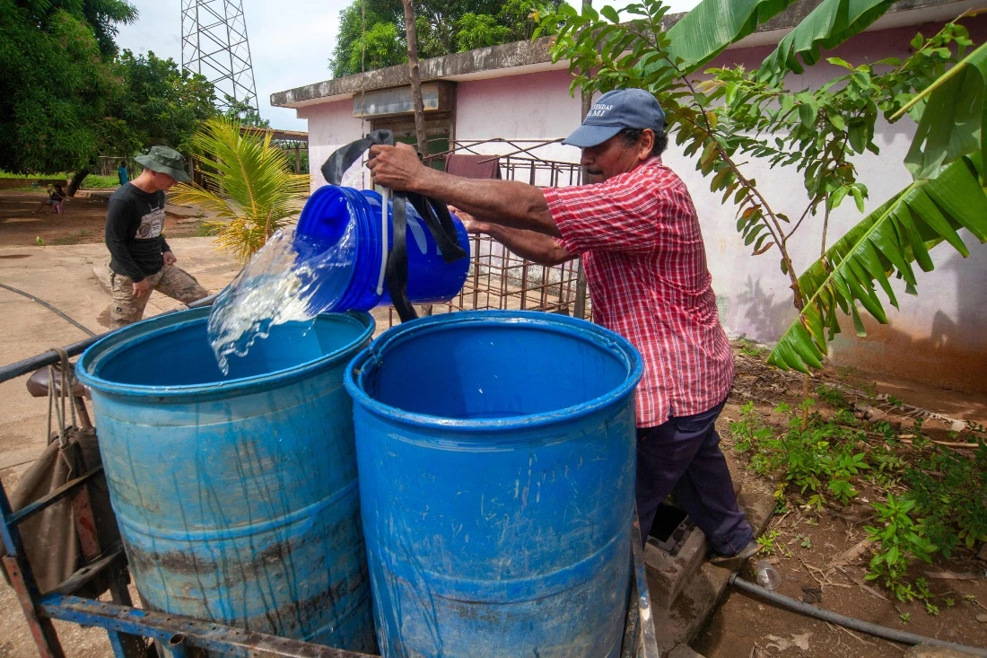 A man fills a drum with water in the Cardoncito 2 neighbourhood in Maracaibo, Venezuela. (AFP)
