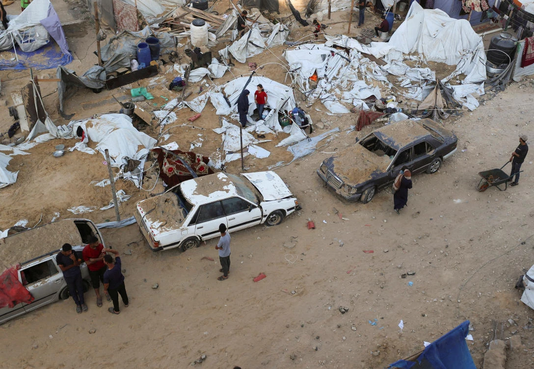 Palestinians gather at the site of a tent camp that was struck by an Israeli airstrike on Friday in Gaza City, on June 28, 2025. (Reuters)