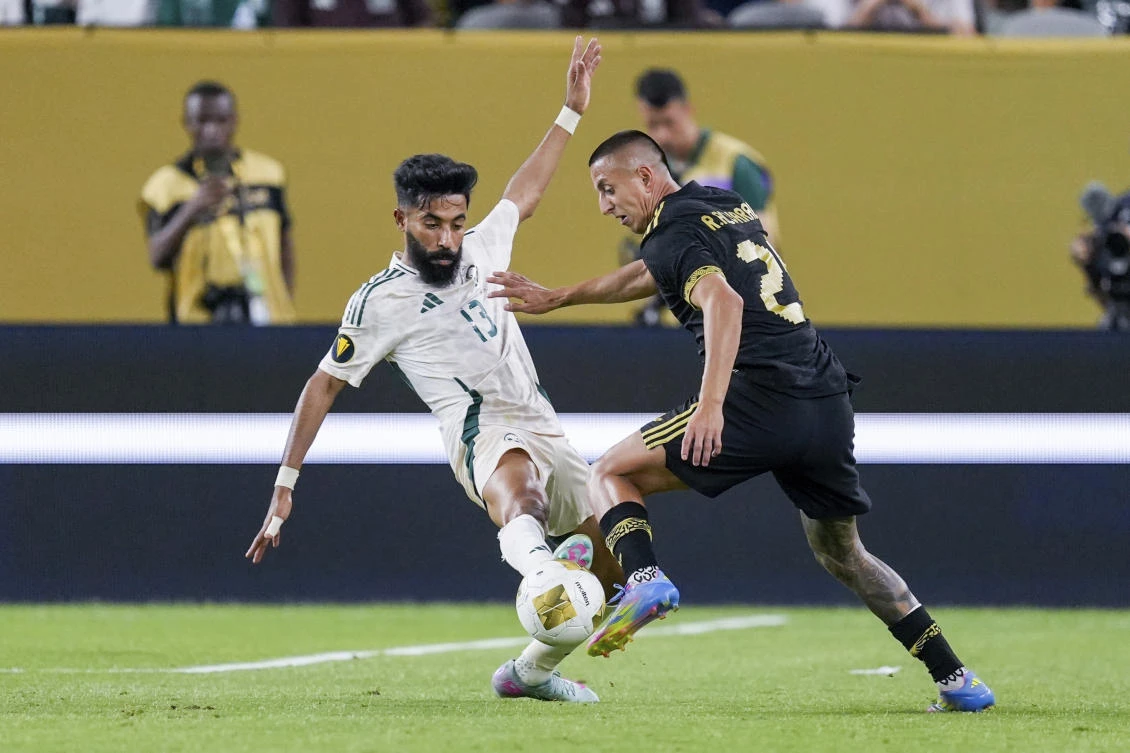 Saudi Arabia defender Nawaf Bu Washl (13) and Mexico midfielder Roberto Alvarado (25) battle for the ball during a CONCACAF Gold Cup quarterfinal soccer match, Saturday, June 28, 2025, in Glendale, Ariz. (AP)