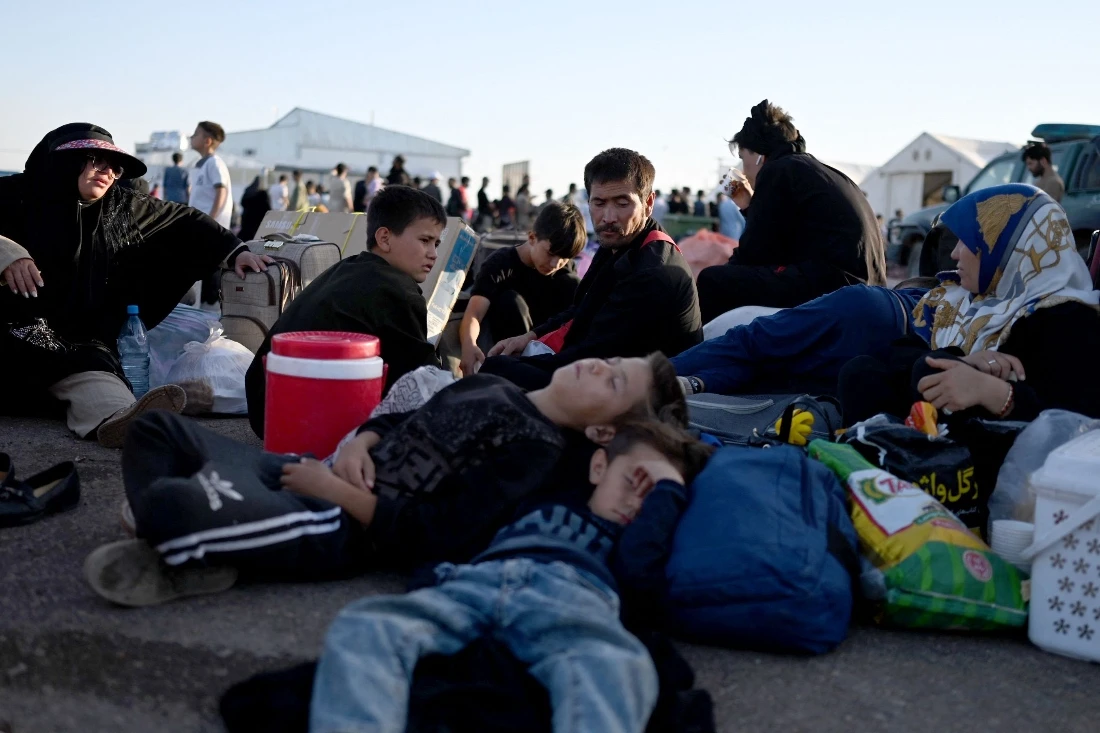 Afghan refugees rest with their luggage at the zero point of the Islam Qala border crossing between Afghanistan and Iran. (AFP)