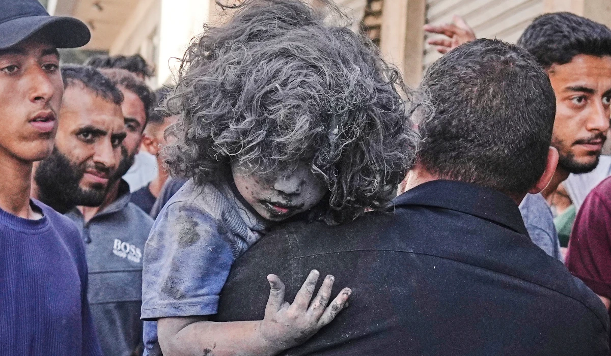 A Palestinian man carries a wounded child after an Israeli strike on a residential building in Gaza, Friday, June 27, 2025. (AP)