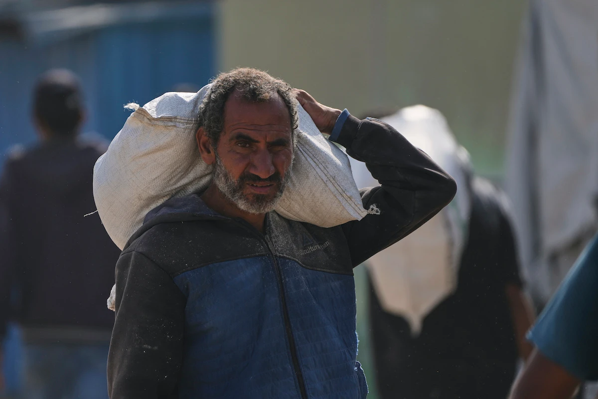A Palestinian man carries a bag of food after receiving aid from the Gaza Humanitarian Foundation. (AP)