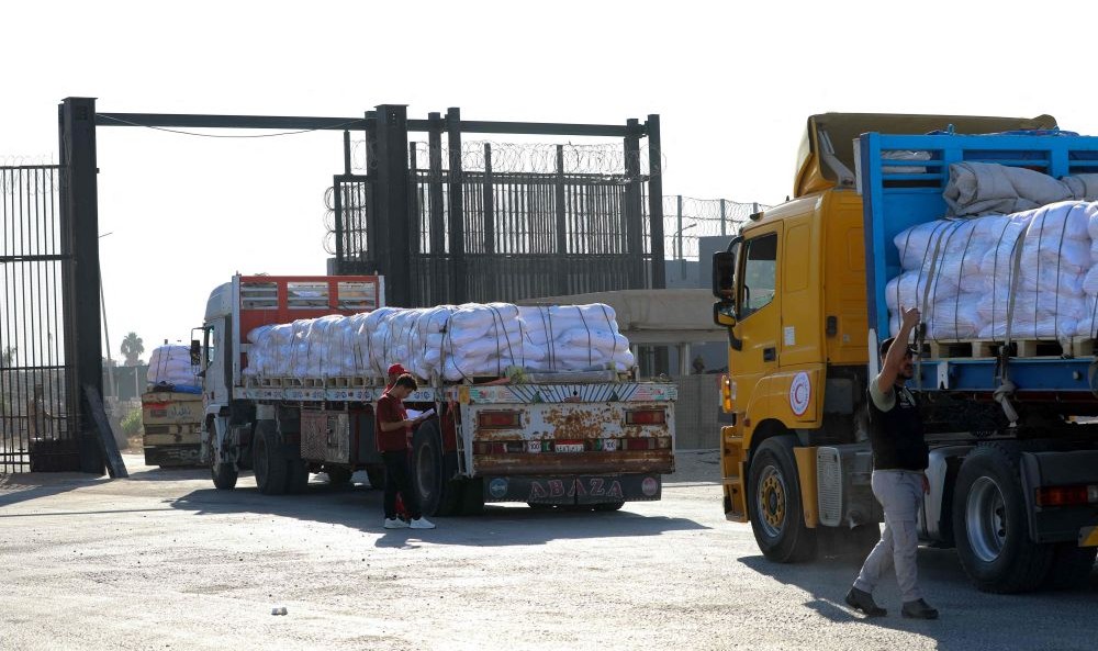 Trucks loaded with humanitarian aid drive toward Gaza through the Egyptian side of the Rafah crossing, July 27, 2025. (AFP)