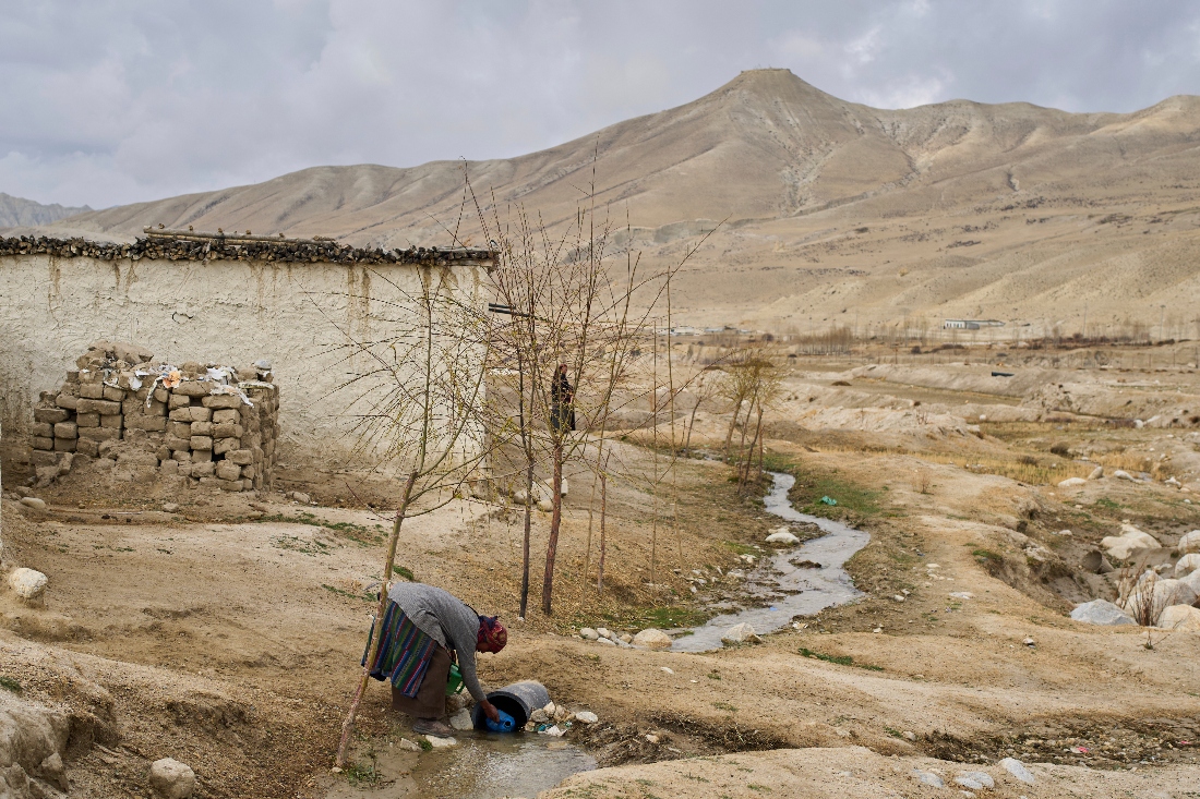 A woman collects water at the newly relocated settlement of the abandoned Samjung village in the Mustang region, Nepal. (AP)