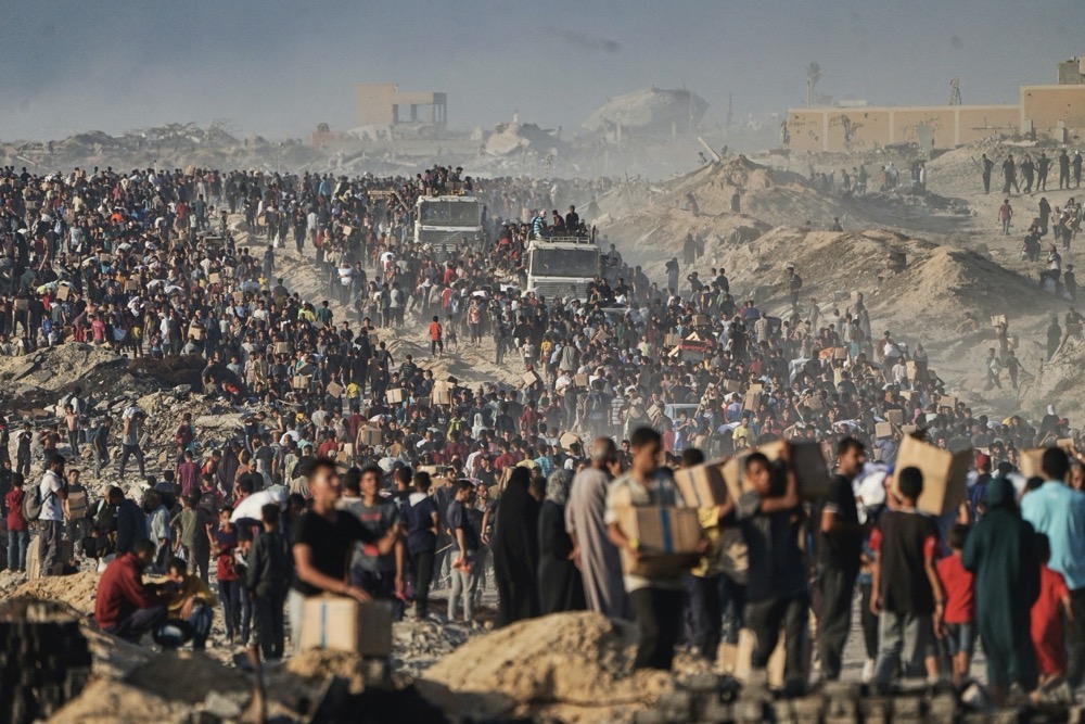 Palestinians carry sacks and boxes of food and humanitarian aid. (AFP/File)