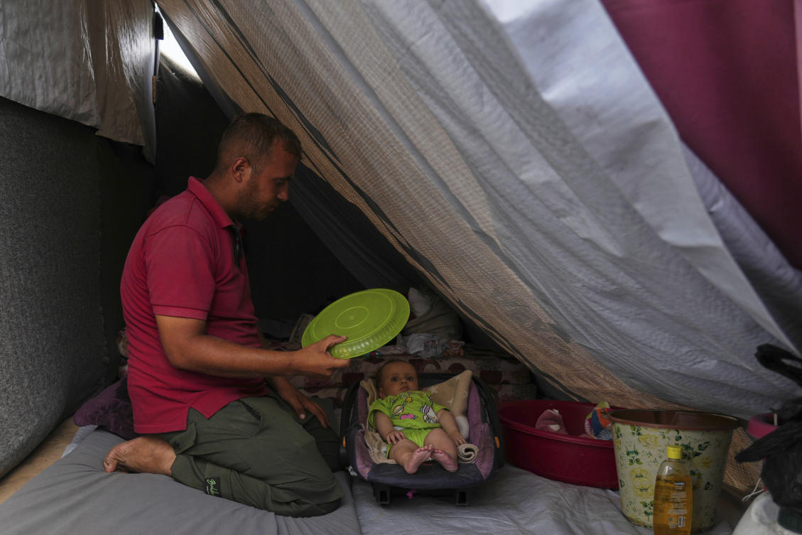 Issam Abu Hadayed, 28, tries to cool off her 5-month-old baby Amira, with a plastic plate as they sit in their tent at a camp for displaced people in Khan Younis, southern Gaza Strip, Tuesday, July 1, 2025. (AP)