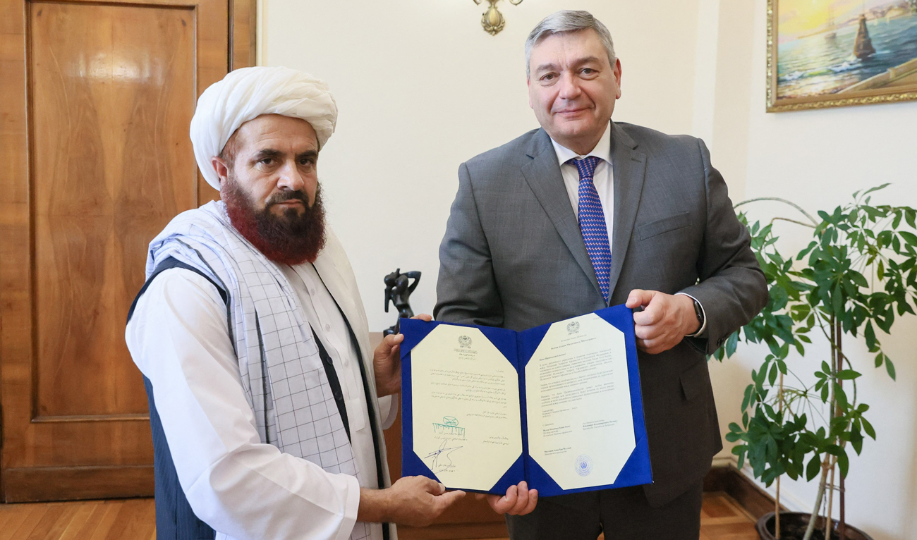In this handout photo released by the Russian Foreign Ministry on July 3, 2025, the newly appointed Taliban envoy to Moscow Gul Hassan hands “copies” of his credence letters to the Deputy Foreign Minister Andrei Rudenko in Moscow. (AFP)