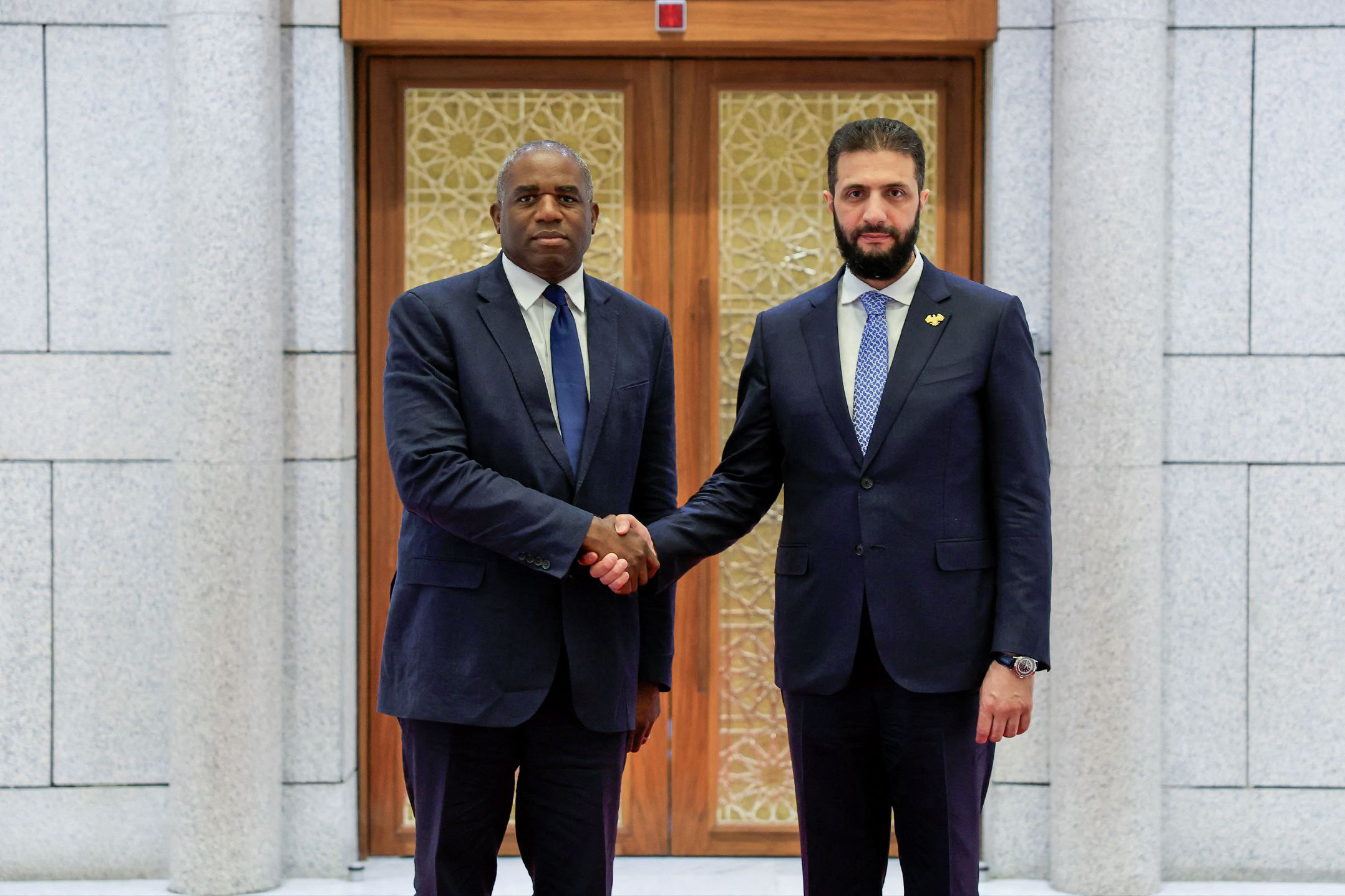 A handout picture released by the official Syrian Arab News Agency (SANA) shows Syria’s interim President Ahmad Al-Sharaa (R) welcoming with British Foreign Secretary David Lammy in the Syrian capital Damascus on July 5, 2025. (AFP via SANA)