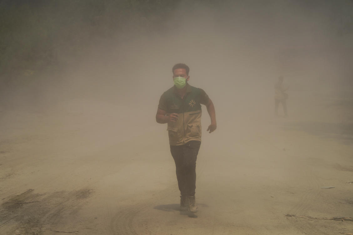 A volunteer runs through smoke from a wildfire, in Latakia countryside, Syria, July 6, 2025. (Reuters)