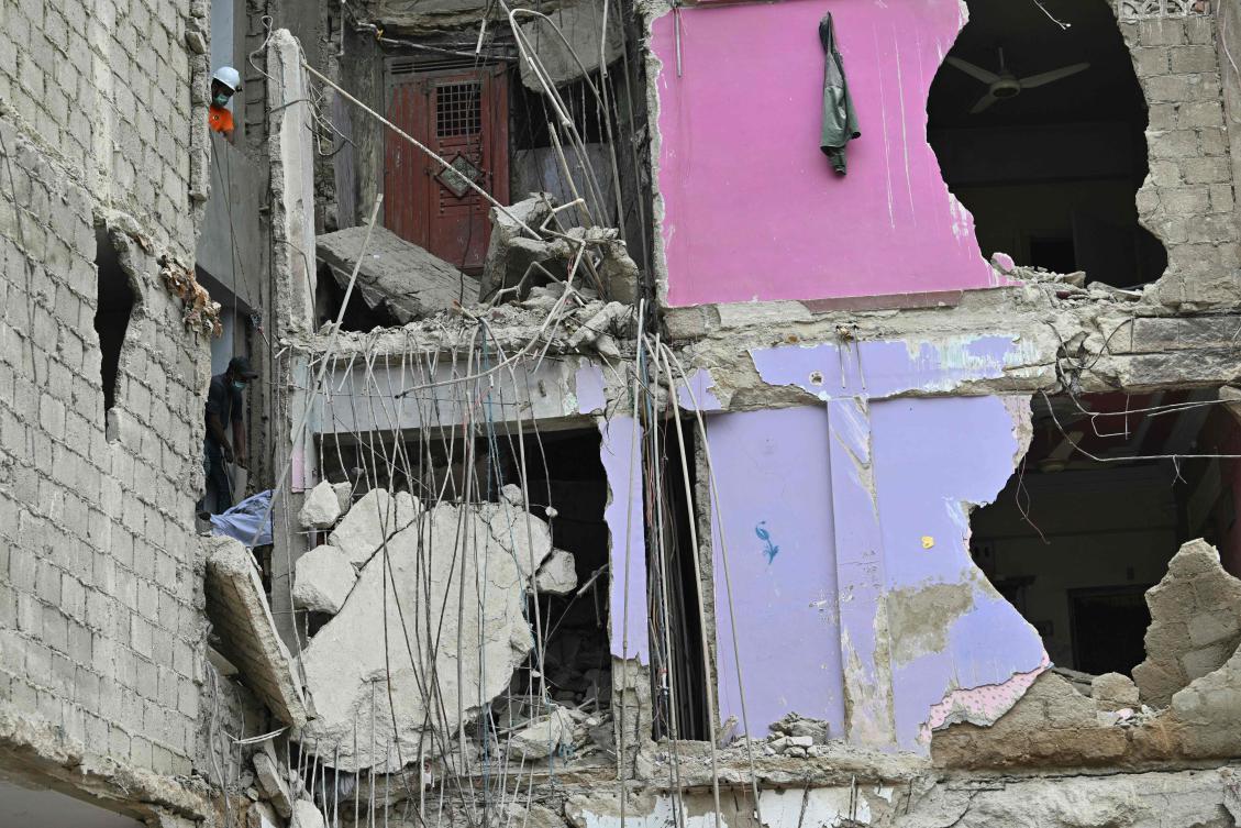 Rescue workers recover a victim's body during a search operation amid the debris of a collapsed residential building in Karachi on July 6, 2025. (AFP)