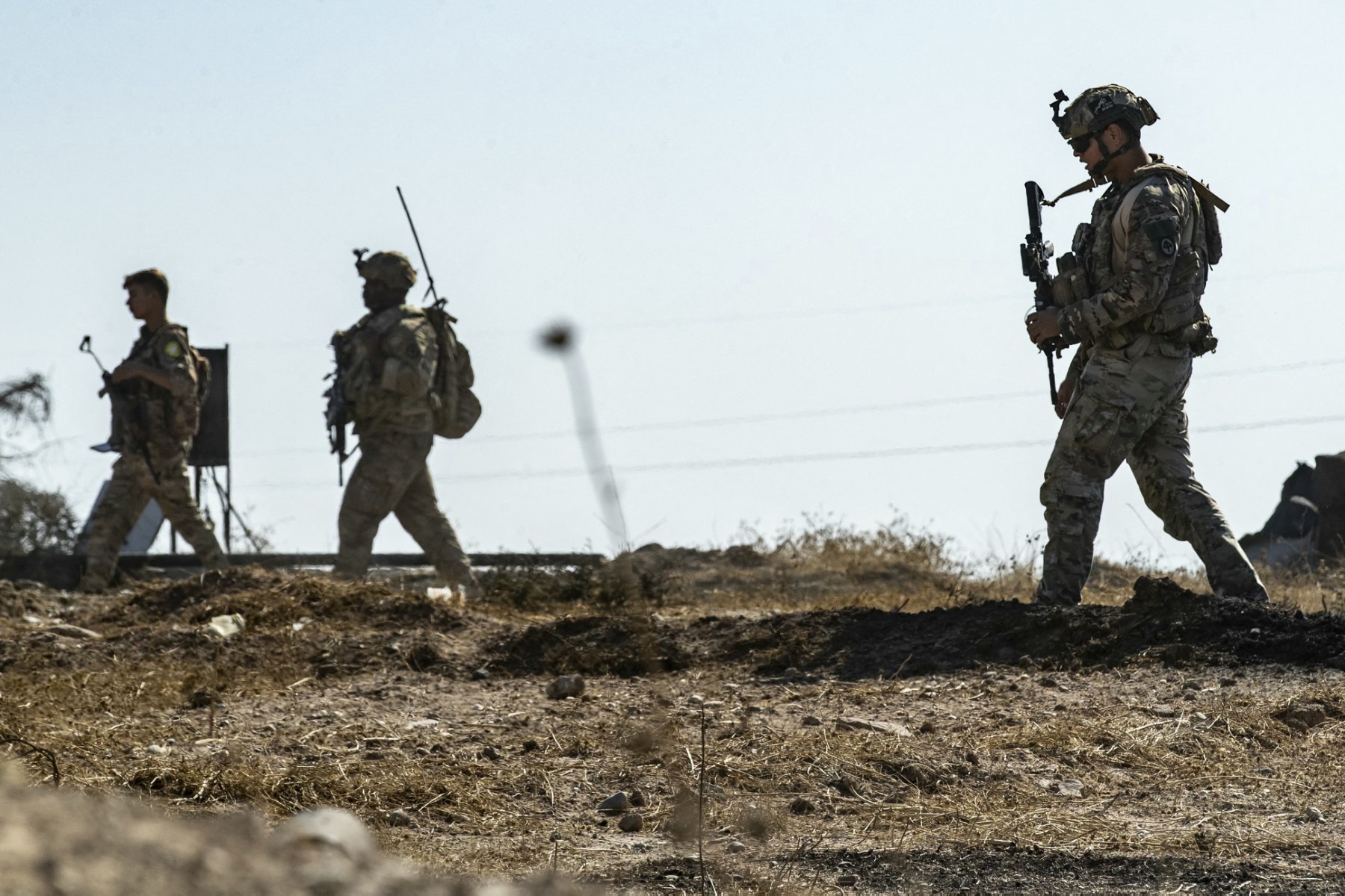 US soldiers inspect the site of reported Turkish shelling days earlier on an oil extraction facility on the outskirts of Rumaylan, in Syria's Kurdish-controlled northeastern Hasakeh province on October 28, 2024. (AFP)