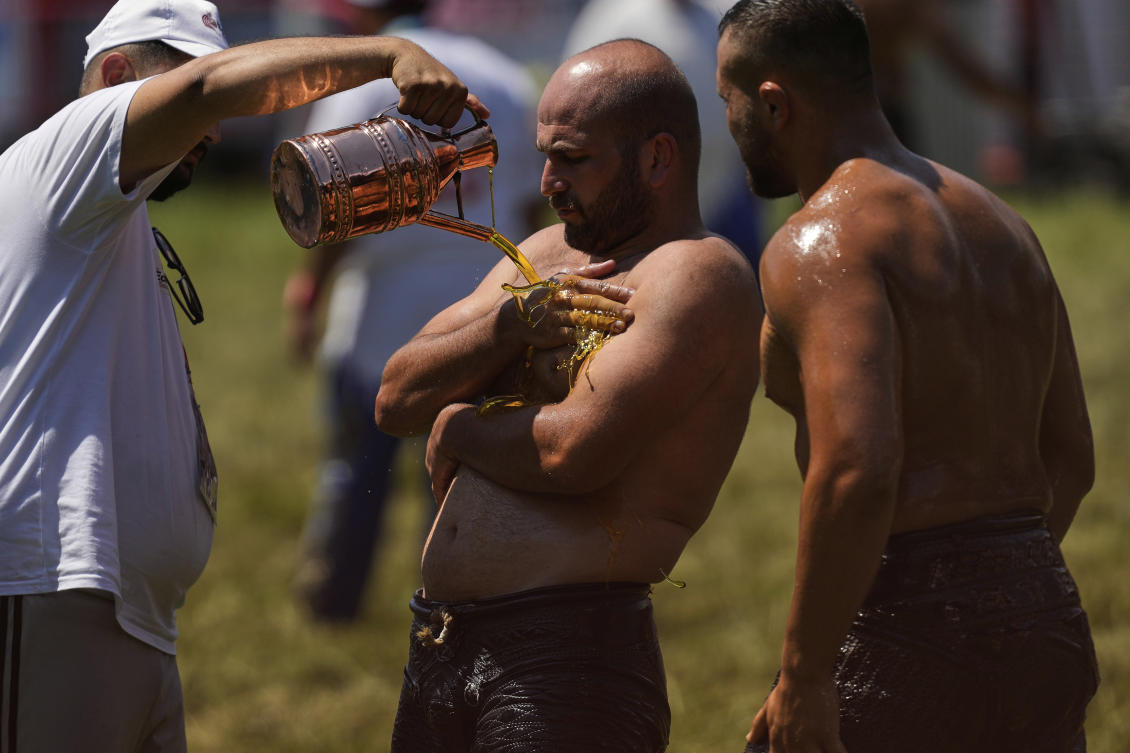 A wrestler is doused in oil by an ‘oiler, during the 664th annual Historic Kirkpinar Oil Wrestling championship, in Edirne, northwestern Turkiye on July 5, 2025. (AP)