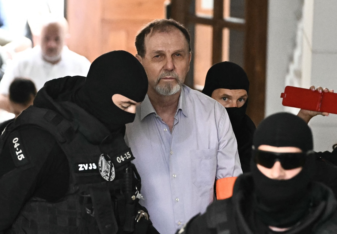 Police escort Juraj Cintula, a 72 year old poet, to the courtroom in Banska Bystrica, Slovakia. (AFP)