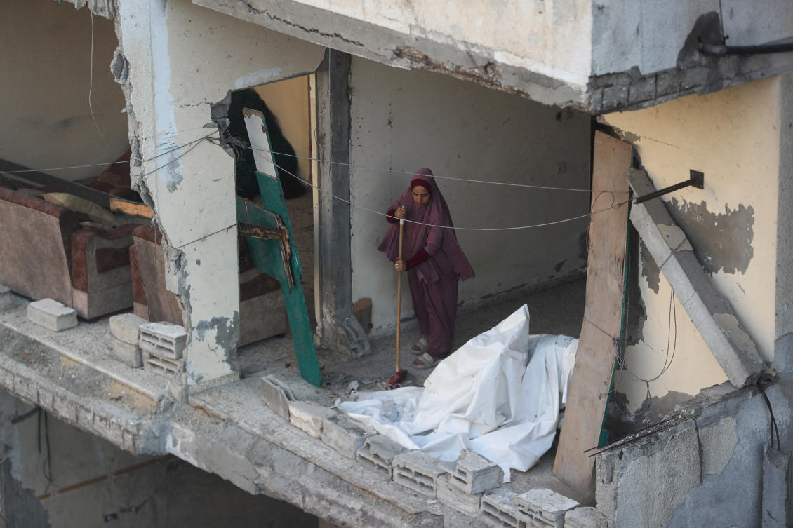 A Palestinian woman sweeps the floor at the site of an overnight Israeli strike on a house, at Shati (Beach) refugee camp in Gaza City, July 9, 2025. (Reuters)